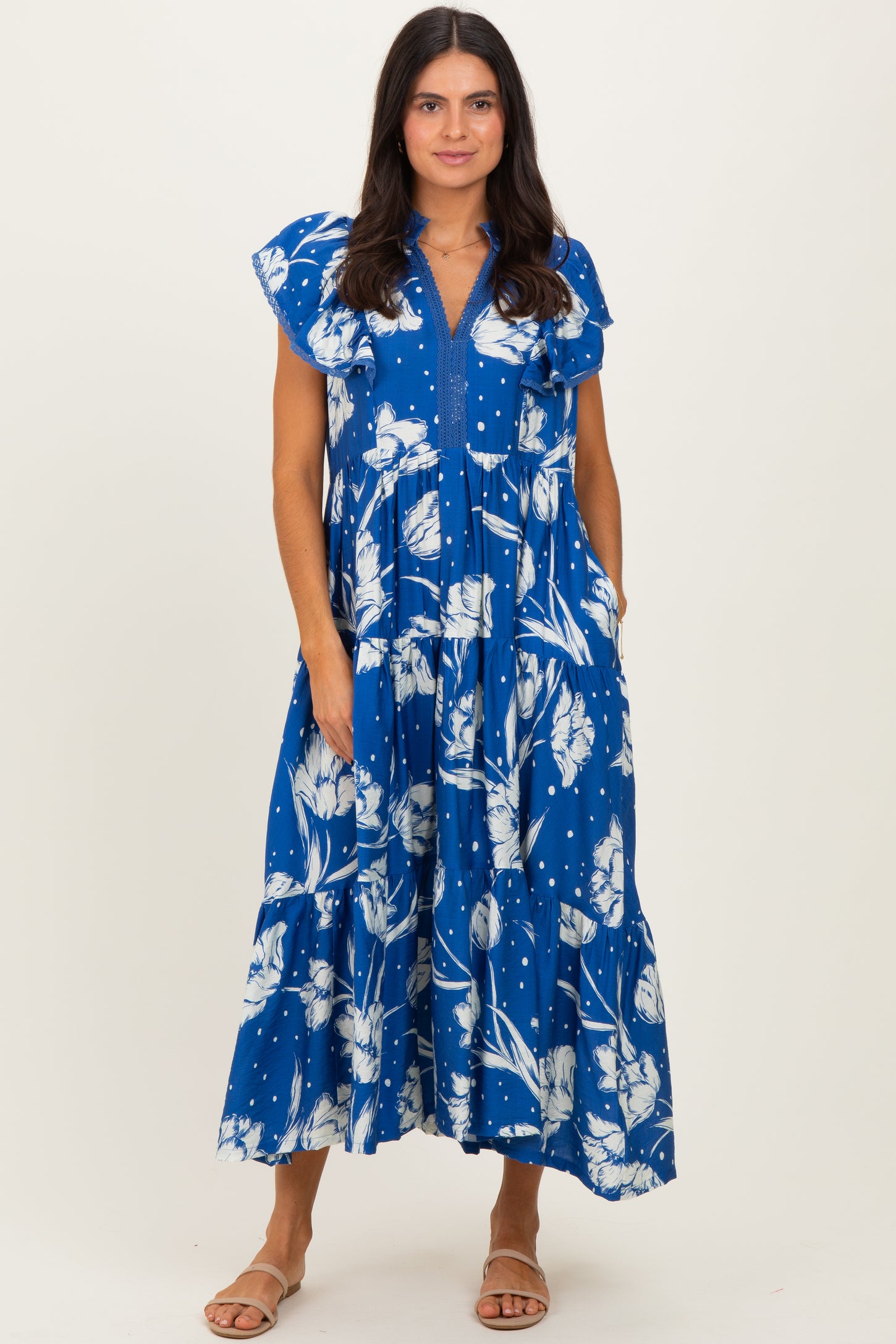 woman wearing a blue floral maxi dress with ruffle sleeves and a v-neckline