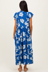 woman wearing a blue floral maxi dress with ruffled sleeves and a tiered skirt, shown from the back