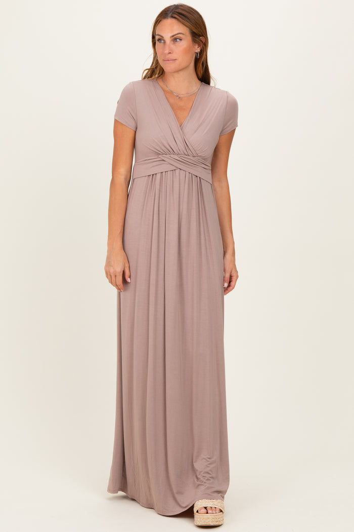 woman wearing a dusty rose short sleeve maxi dress with a wrap design and gathered waistline
