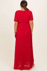 woman wearing a red lace maternity maxi dress with short sleeves and a tie waist detail, showing a baby bump