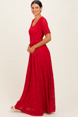 woman wearing a red lace maxi dress with short sleeves and a tie waist detail