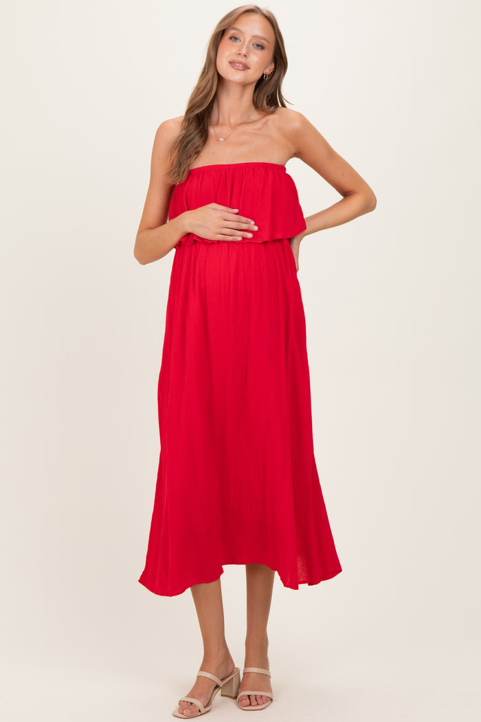 woman wearing a red strapless maternity dress with a gathered bodice and baby bump visible