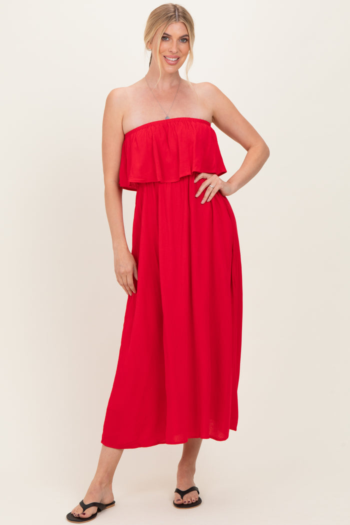 woman wearing a red strapless maxi dress with a ruffled bodice and black flip-flops