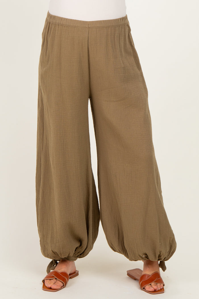 maternity wear in olive green wide-leg pants with gathered ankles, styled with brown sandals