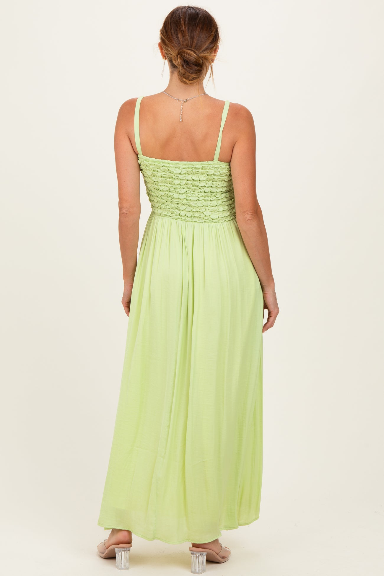 woman wearing a back view of a light green maxi dress with a smocked bodice and adjustable straps