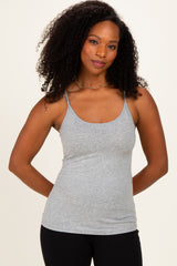 woman wearing a gray spaghetti strap tank top with a fitted style and black leggings