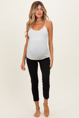 woman wearing a gray maternity tank top and black maternity leggings, showing her baby bump