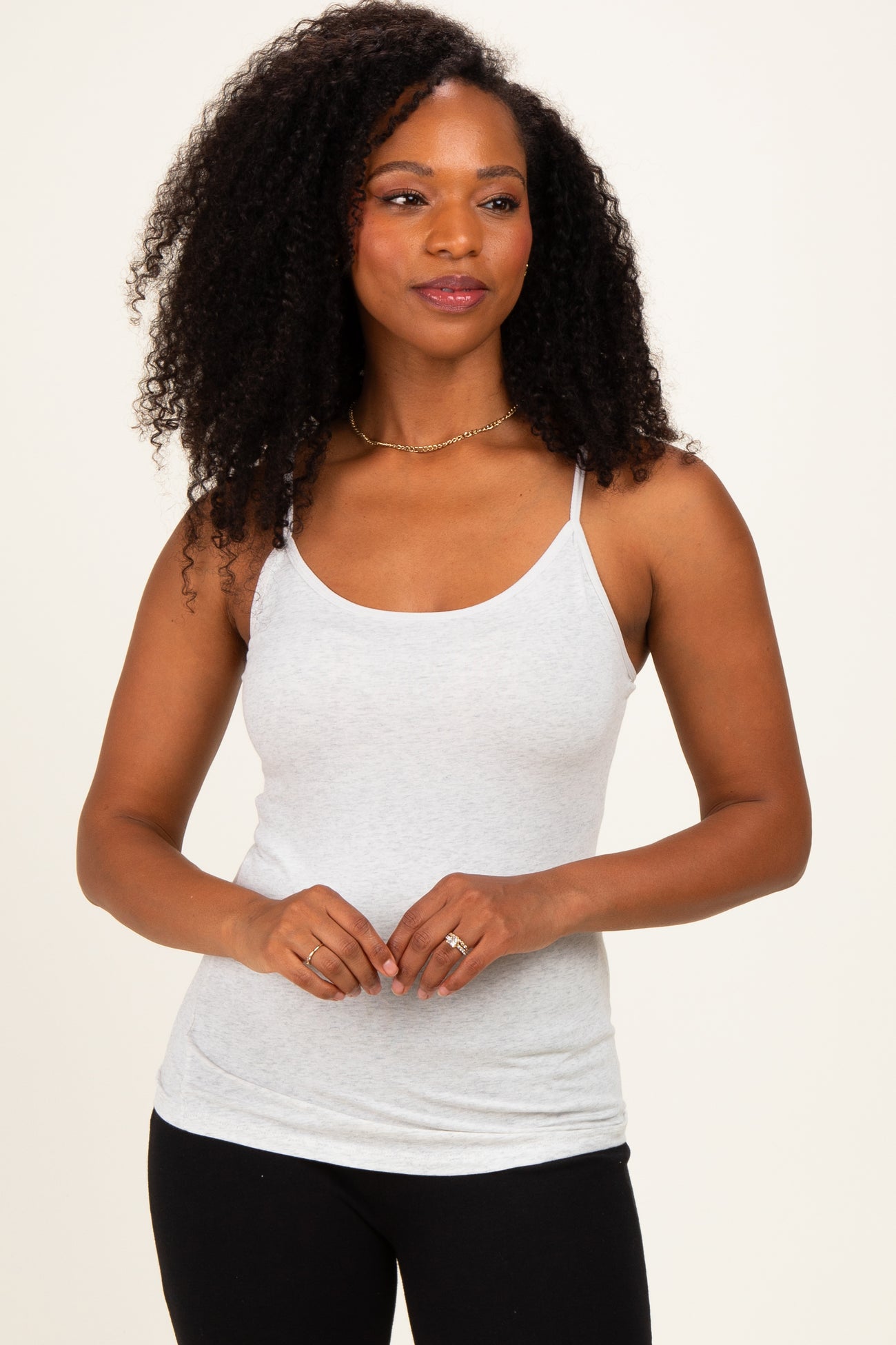 woman wearing a light gray spaghetti strap tank top with a relaxed fit and a scoop neckline