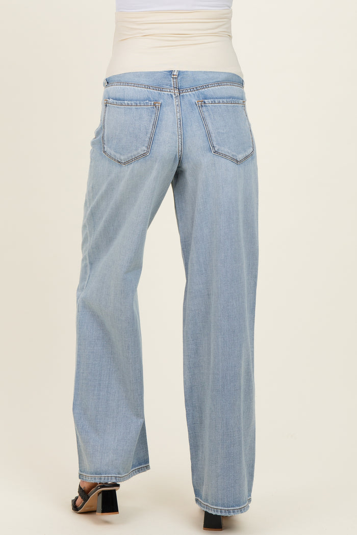 woman wearing light wash maternity jeans with a wide-leg style and an elastic pregnancy-friendly waistband