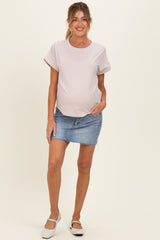 woman wearing a striped maternity top with short sleeves and a denim skirt, showcasing a subtle baby bump