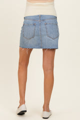 woman wearing a light blue denim maternity mini skirt with frayed hem and back pockets