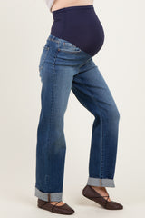 woman wearing maternity dark wash straight leg jeans with a navy over-the-bump waistband and cuffed hems, baby bump visible
