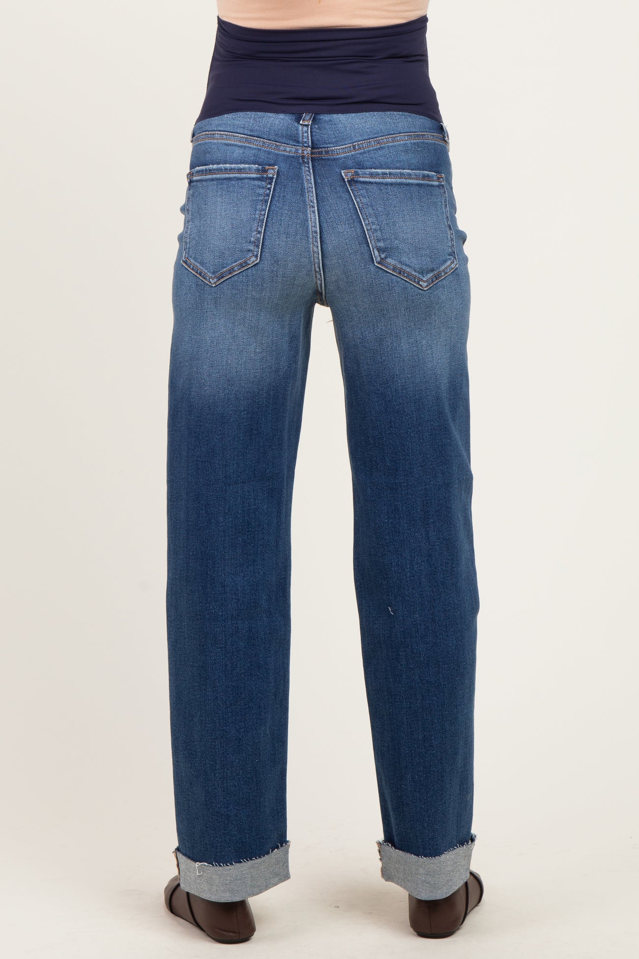 woman wearing a pair of cuffed light blue maternity jeans viewed from the back