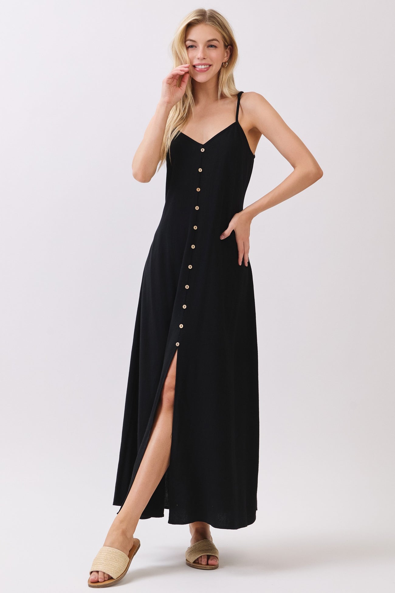 woman wearing a black button-down maxi dress with a thigh-high slit and spaghetti straps