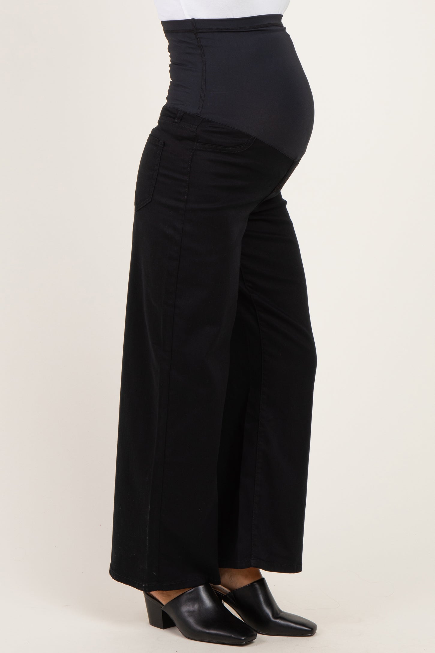 woman wearing black maternity trousers with a stretchy over-the-bump waistband and a visible baby bump