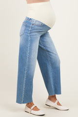 woman wearing light blue wide-leg maternity jeans with a stretchy belly panel, showing a baby bump