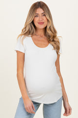 woman wearing a white short sleeve maternity top and showing her baby bump
