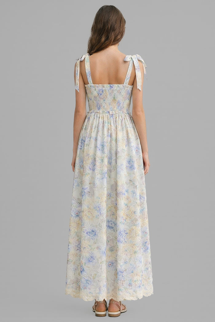 woman wearing a floral maxi dress with tie straps and a smocked back