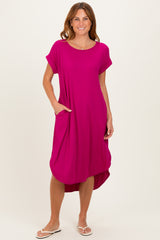 woman wearing a vibrant pink short sleeve midi dress with side pockets and a high-low hemline