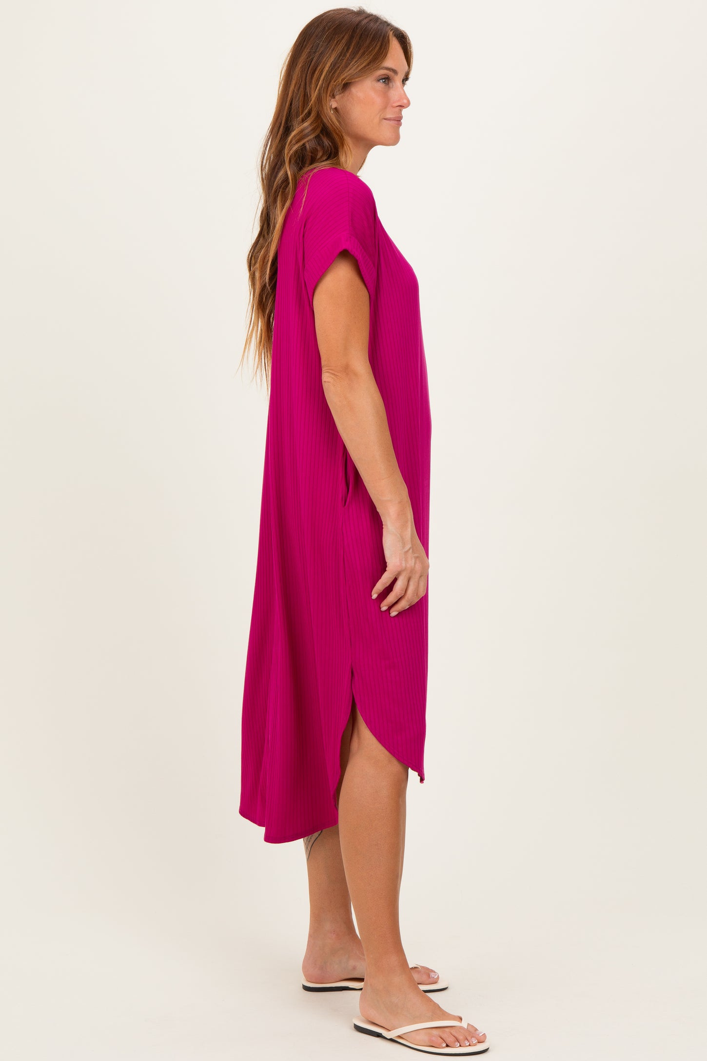 woman wearing a vibrant magenta short sleeve dress with side slits and a relaxed fit