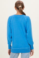 woman wearing a bright blue maternity sweatshirt with a relaxed fit, showing the back view