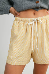 woman wearing yellow and white striped drawstring shorts with an elastic waistband