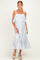 woman wearing a white and blue striped maternity dress with a layered ruffle detail and a flowy hem, showcasing her baby bump