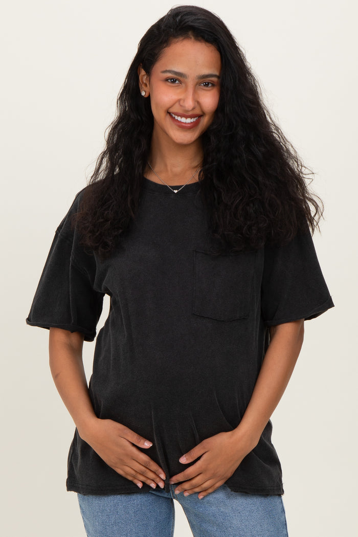 woman wearing a black oversized maternity t-shirt with a front pocket and holding her baby bump