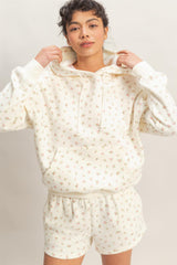 woman wearing a cream floral print hoodie and matching shorts with an elastic waistband