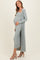 woman wearing a mint green ribbed maternity dress with a long cardigan and displaying her baby bump