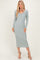 woman wearing a light green ribbed midi dress with long sleeves and a v-neckline