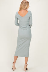 woman wearing a light green ribbed midi dress with a deep v-back and long sleeves