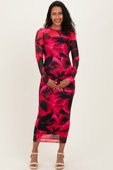 woman wearing a red and black floral long sleeve maternity dress and holding her baby bump