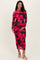 woman wearing a long sleeve pink and black floral print maternity dress and holding her baby bump