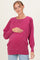 woman wearing a fuchsia maternity sweatshirt with a relaxed fit and baby bump visible