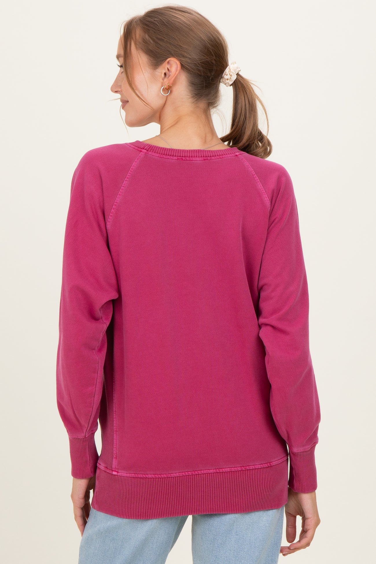 woman wearing a pink maternity sweatshirt, viewed from the back, with long sleeves and a relaxed fit