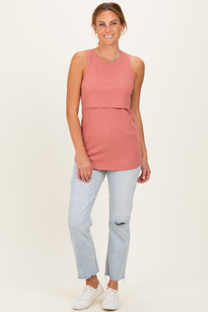 woman wearing a rust-colored ribbed sleeveless top with a layered effect and light blue distressed jeans