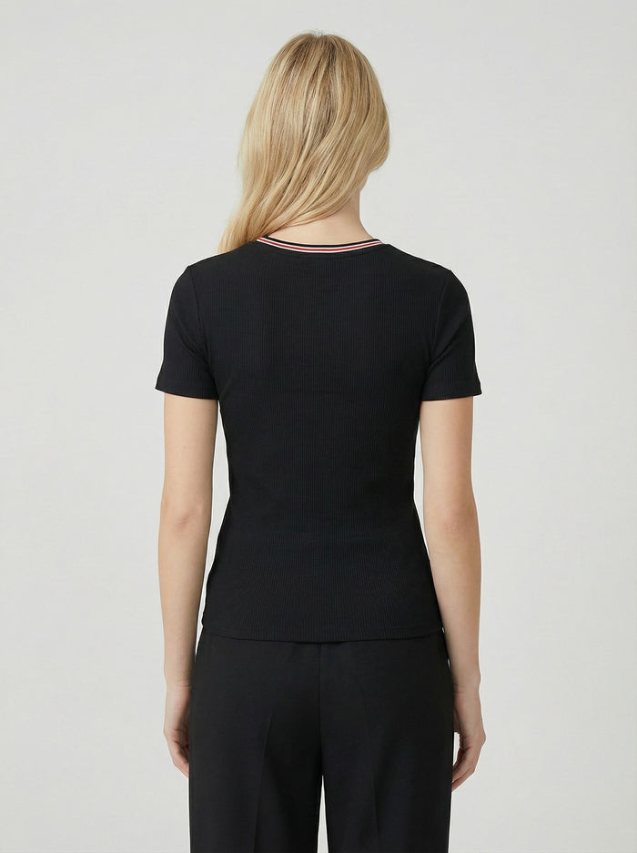 woman wearing a black ribbed short sleeve top, shown from the back, paired with black pants