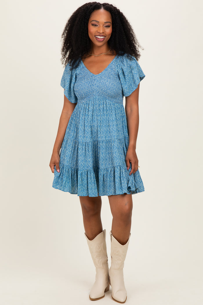 woman wearing a blue tiered sundress with ruffled sleeves and cowboy boots