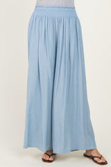 woman wearing light blue wide-leg pants with a smocked waistband and paired with flat sandals