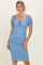 woman wearing a light blue polka dot fitted midi dress with puff sleeves and a square neckline
