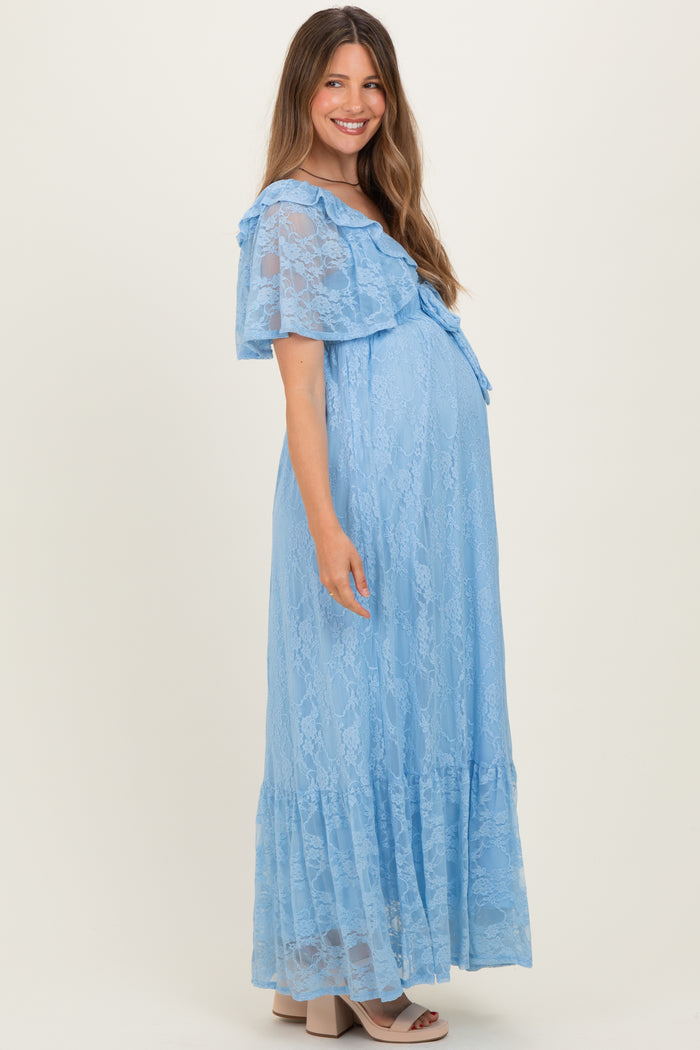 woman wearing a light blue lace maternity dress with ruffled sleeves and a flowy skirt, showing her baby bump
