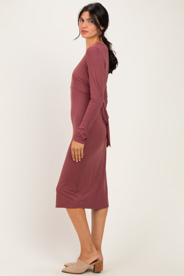 woman wearing a mauve long sleeve midi dress with a tie detail at the waist and slip-on heels