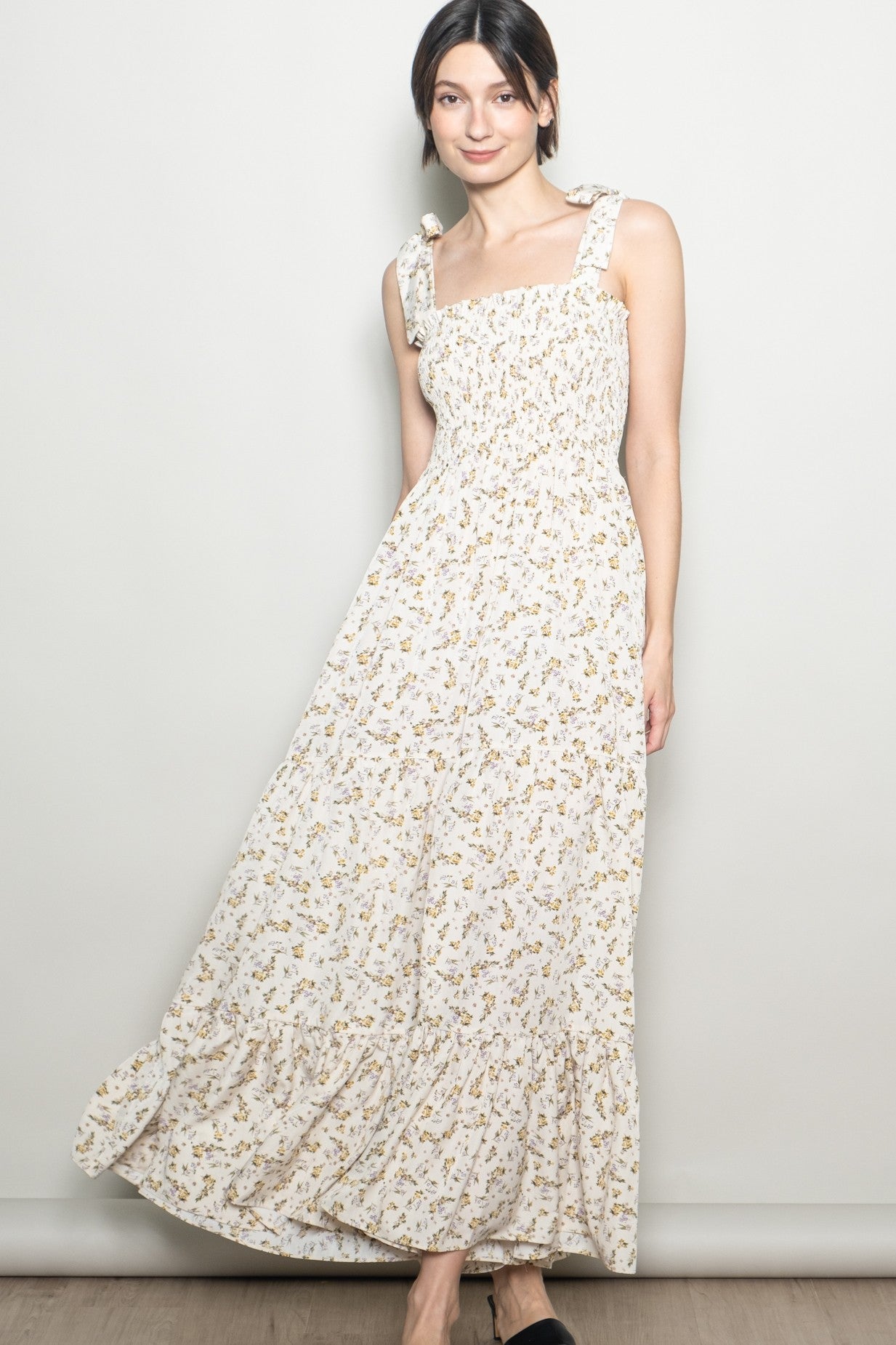woman wearing a white floral print maxi dress with ruffled straps and a smocked bodice