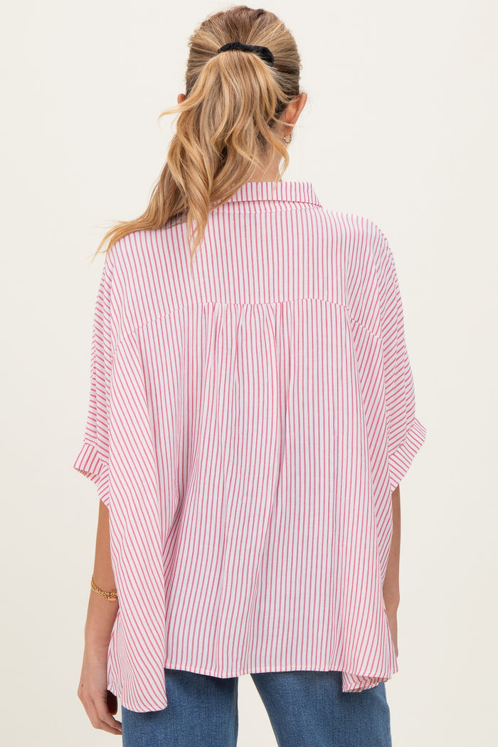 woman wearing a pink and white striped maternity top with a relaxed fit and short sleeves, showing the back view