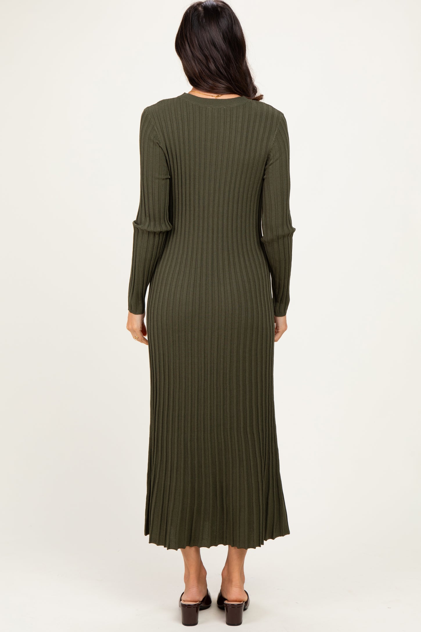 woman wearing a long olive green ribbed dress with long sleeves and a fitted silhouette, viewed from the back