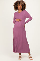 woman wearing a mauve long sleeve ribbed maternity dress, gently holding her baby bump