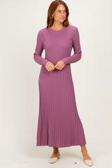 woman wearing a long sleeve ribbed mauve maxi dress with a scalloped hemline and standing confidently