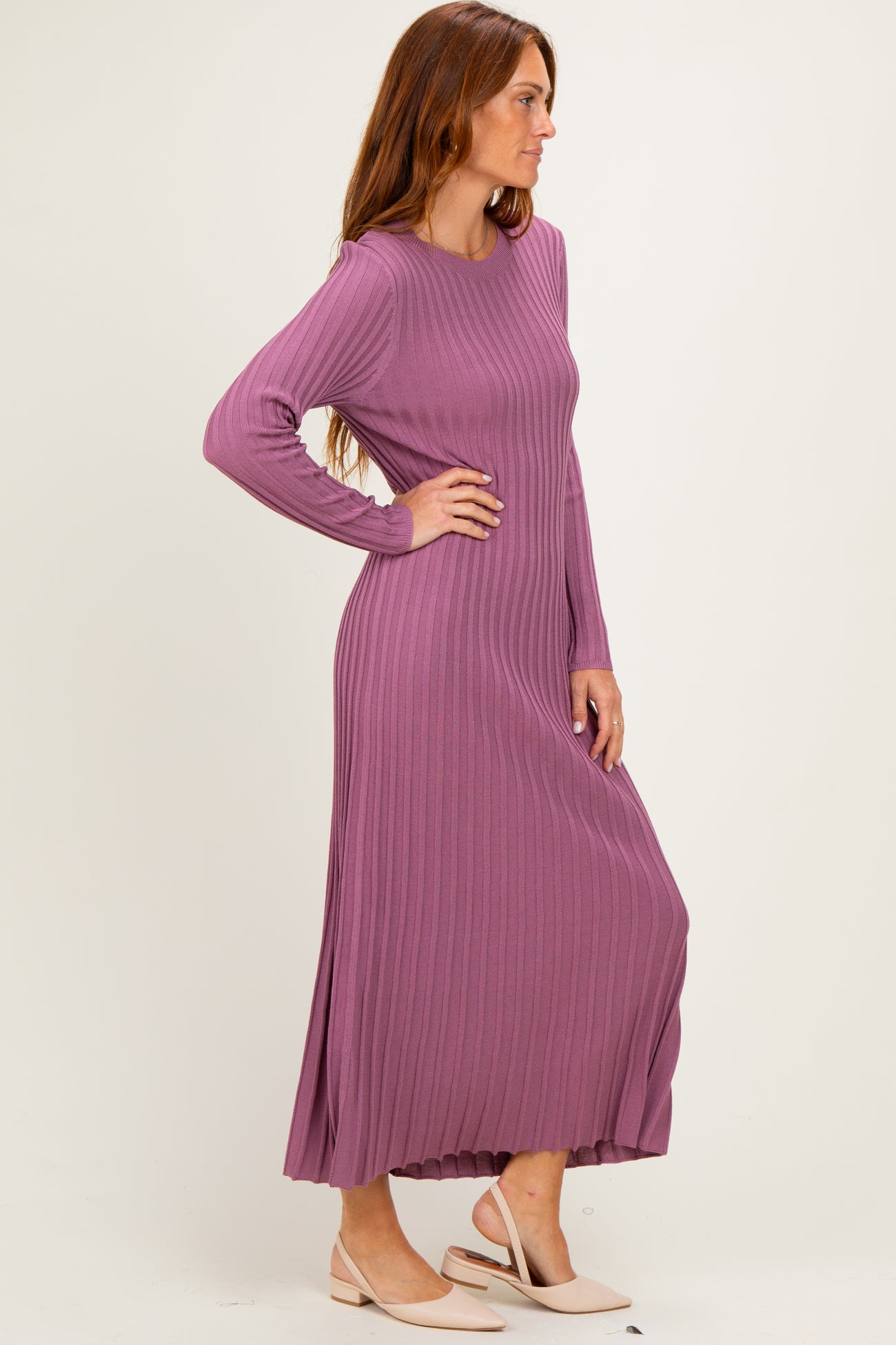 woman wearing a long sleeve ribbed maxi dress in mauve with a relaxed fit and side slits