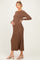 woman wearing a brown ribbed long sleeve maternity dress and posing with her baby bump